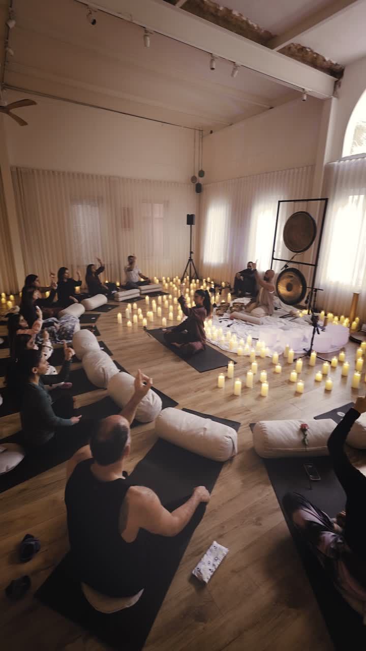 A group lying on mats during a candlelit sound journey
