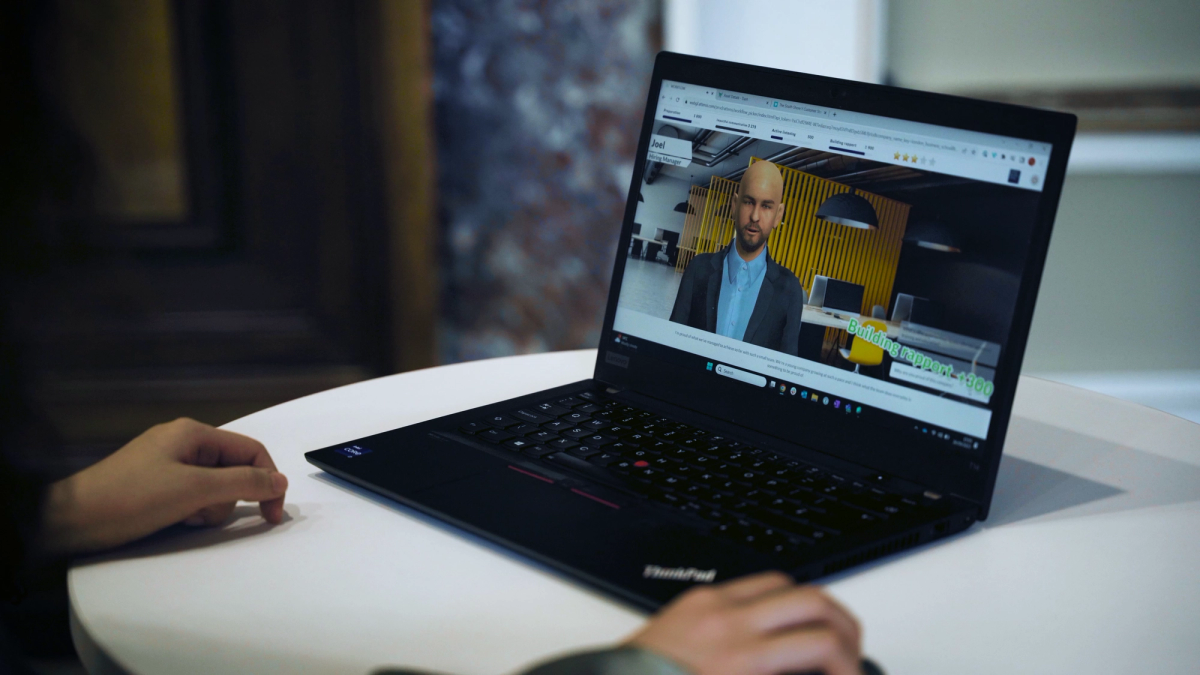 Hände an einem Laptop mit einer 3D-Avatar-Simulation und einem grünen Score-Popup „Building rapport +300“