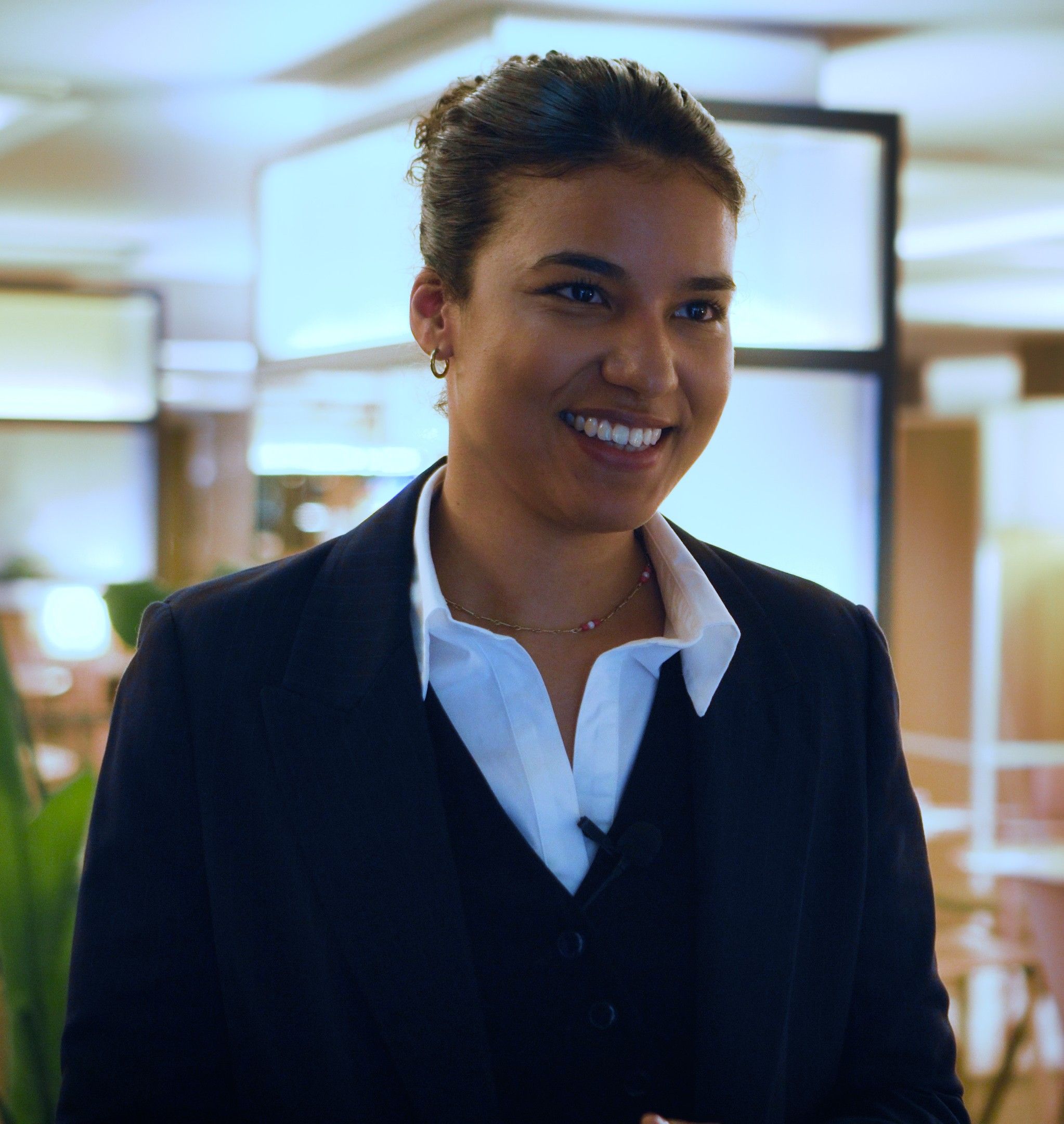 Francesca lächelt während eines gefilmten Interviews in dunklem Anzug und weißem Hemd