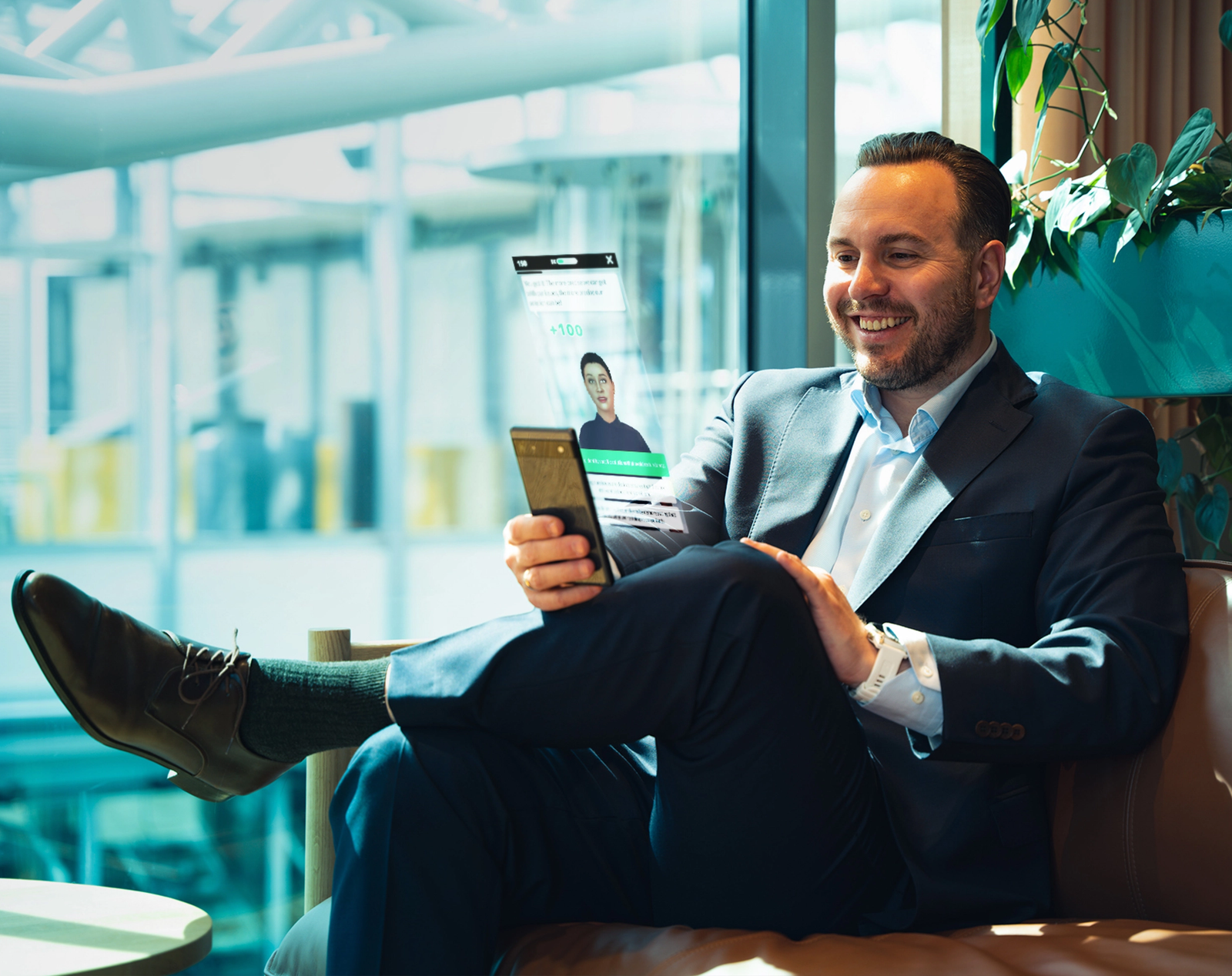Smilende mann i dress som samhandler med en holografisk projeksjon fra smarttelefonen sin.