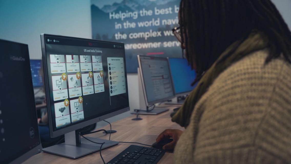 Person in front of a screen showing US and India training modules with star ratings