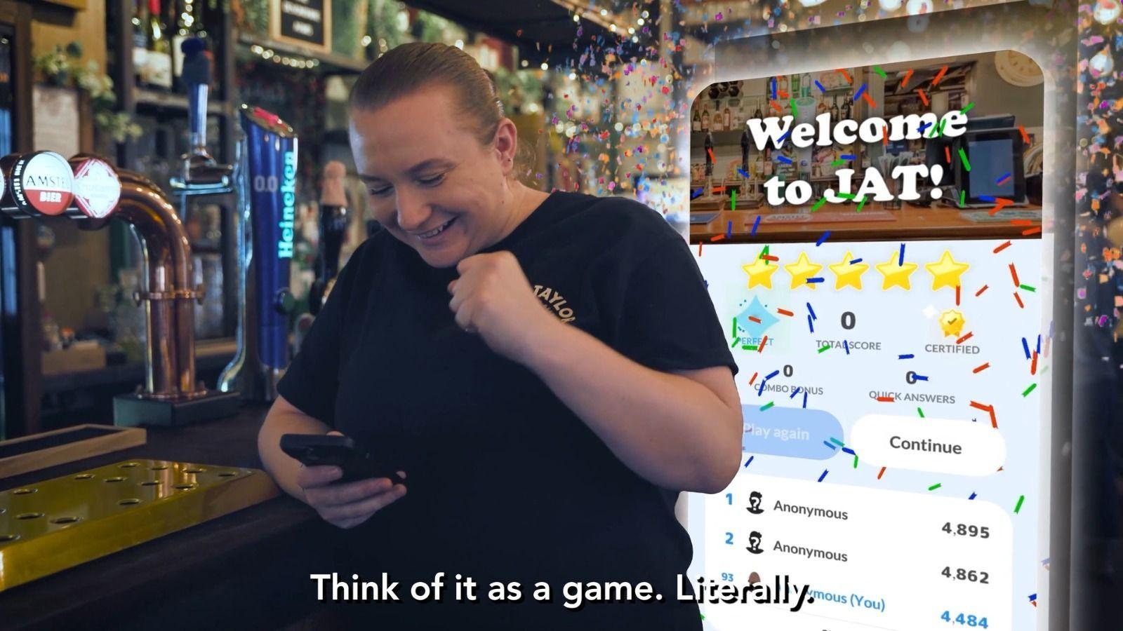Eine Pub-Mitarbeiterin lächelt hinter der Theke auf ihr Handy, daneben ein eingeblendeter App-Bildschirm mit dem Text Welcome to JAT