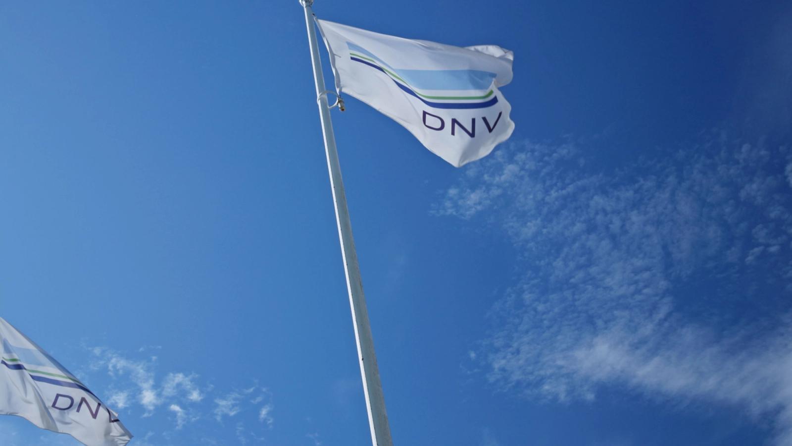 Zwei DNV-Flaggen an Masten vor klarblauem Himmel