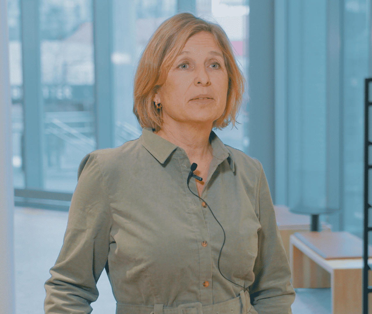 Nina Arnessen mit Ansteckmikrofon in einem hellen, modernen Büro