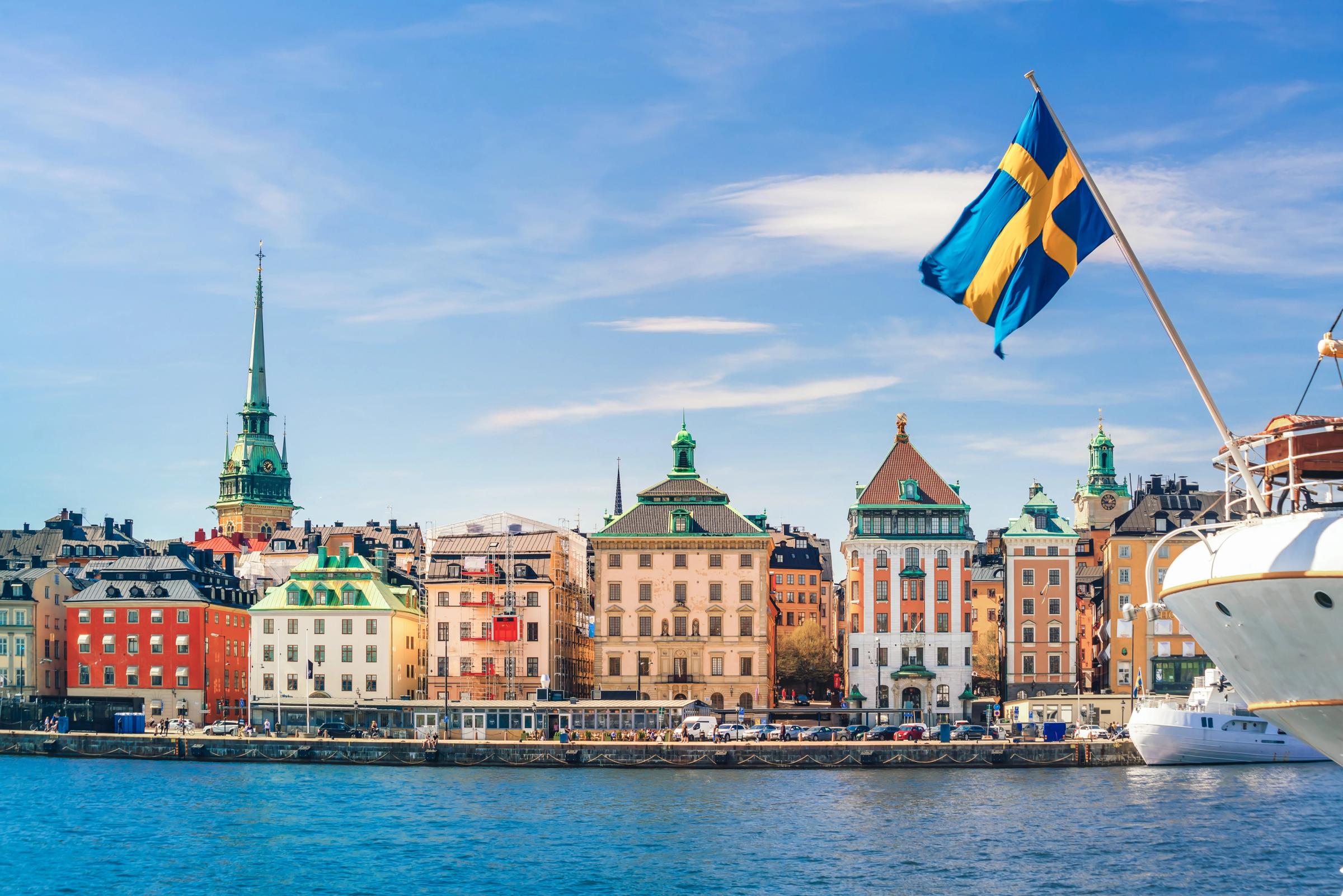 Stockholm old town waterfront with a Swedish flag on a sunny day
