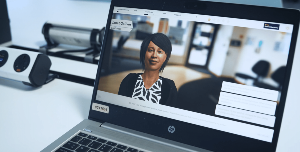 Attensi-Simulation auf einem Laptop mit der virtuellen Kundin Janet Galiver und Antwortoptionen für den Dialog