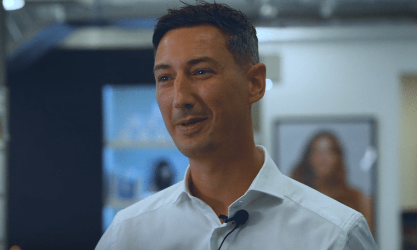 Seb Lucas speaking during an interview, with product shelves behind him