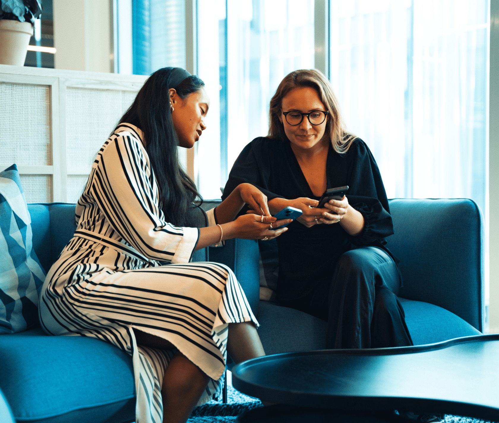 Zwei Frauen spielen Führungskräftetraining auf ihren Smartphones