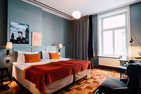 Scandic Hotels superior room with a double bed, orange cushions and a red throw