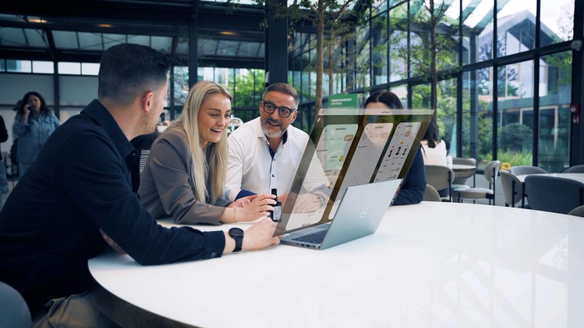 Davines team members gathered around a laptop showing the training app