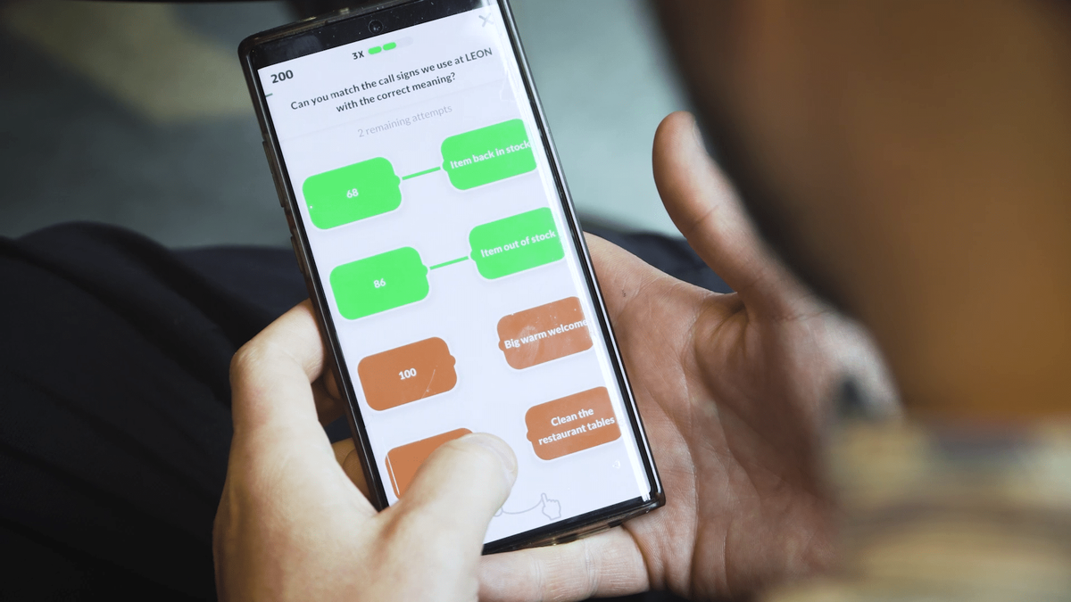 Person som spelar Attensi SKILLS, en spelbaserad träning, på en smartphone