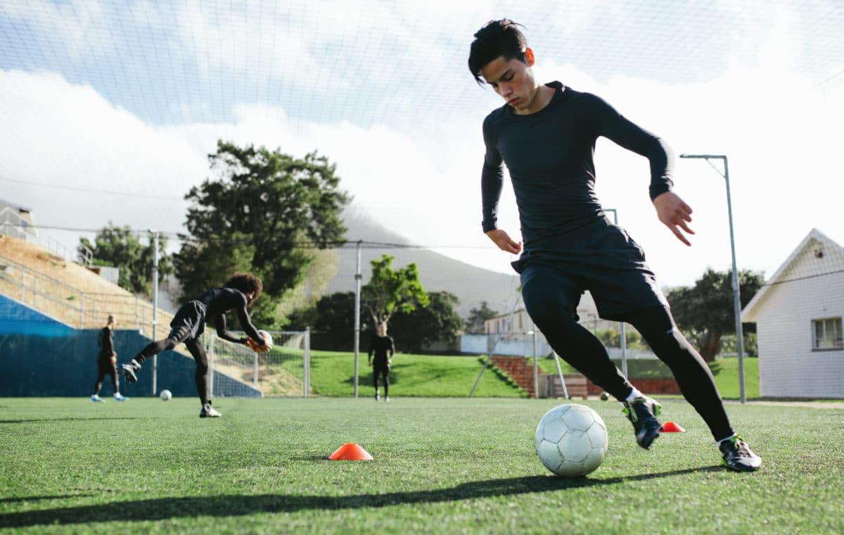 Football Player Training In Soccer Field Young Soccer Player Practicing