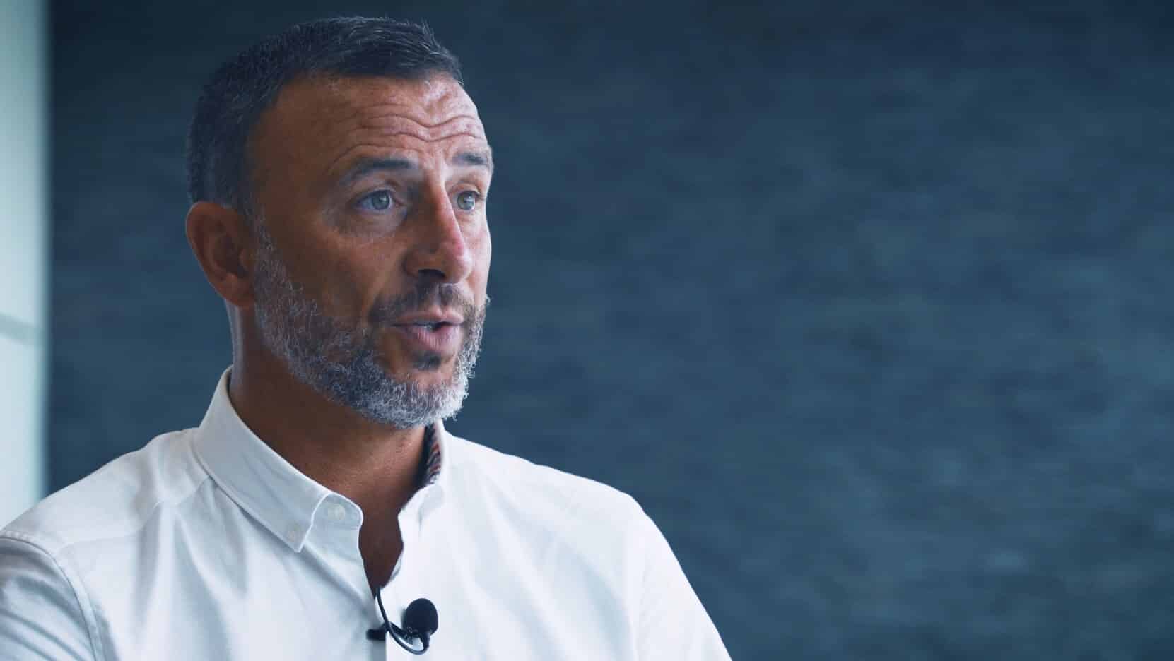Craig Miller, bearded man in a white shirt speaking in an interview
