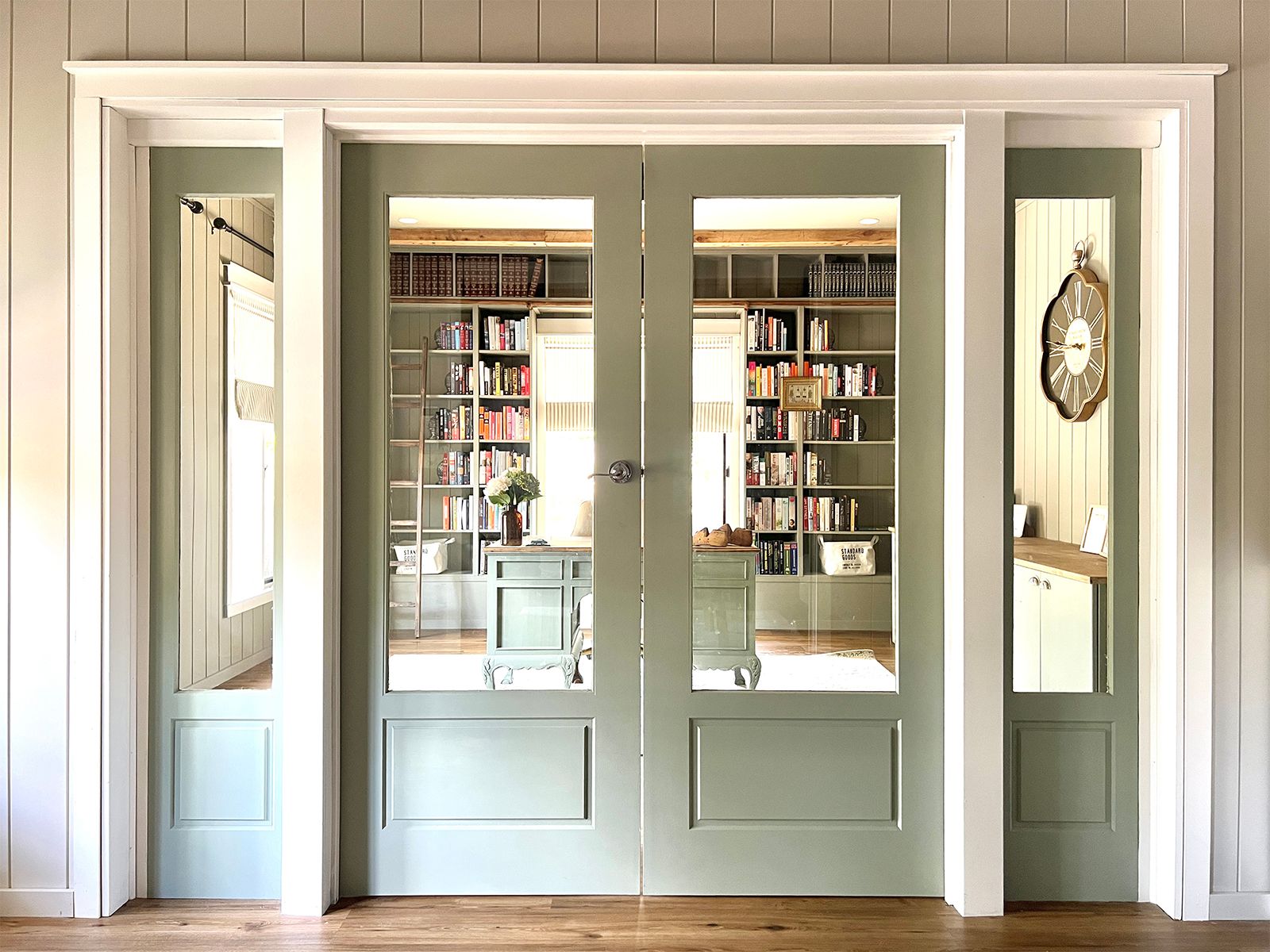 Elegant mint-green Bayview BAY100 internal double doors open to a cozy library, featuring bookshelves filled with colourful books and a central desk, creating a serene atmosphere.