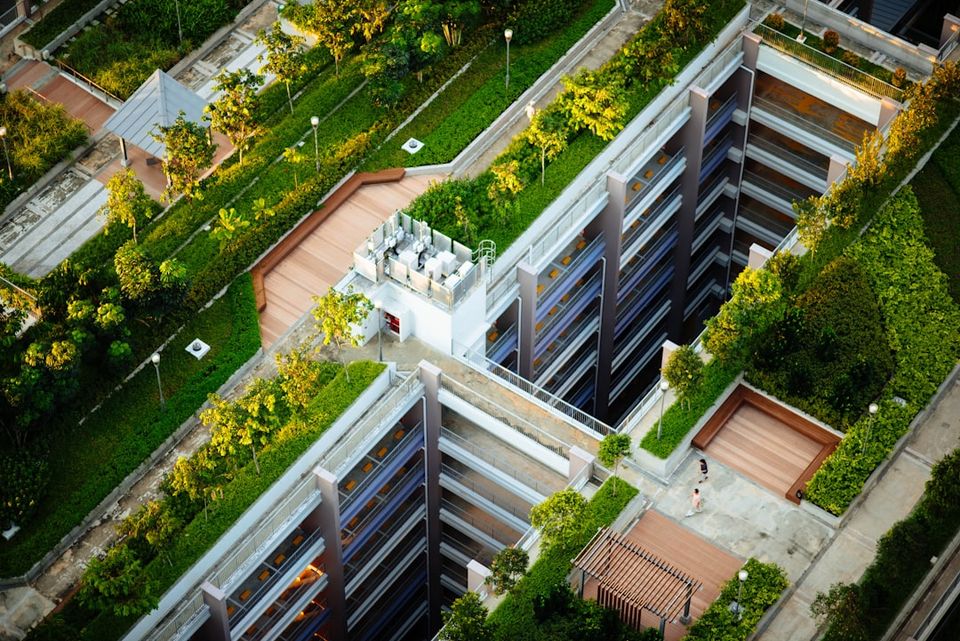 Overhead view of a multi-level structure featuring extensive green roofs, lush rooftop gardens, and sustainable landscaping, exemplifying eco-friendly architecture and green design to attract eco-conscious clients.