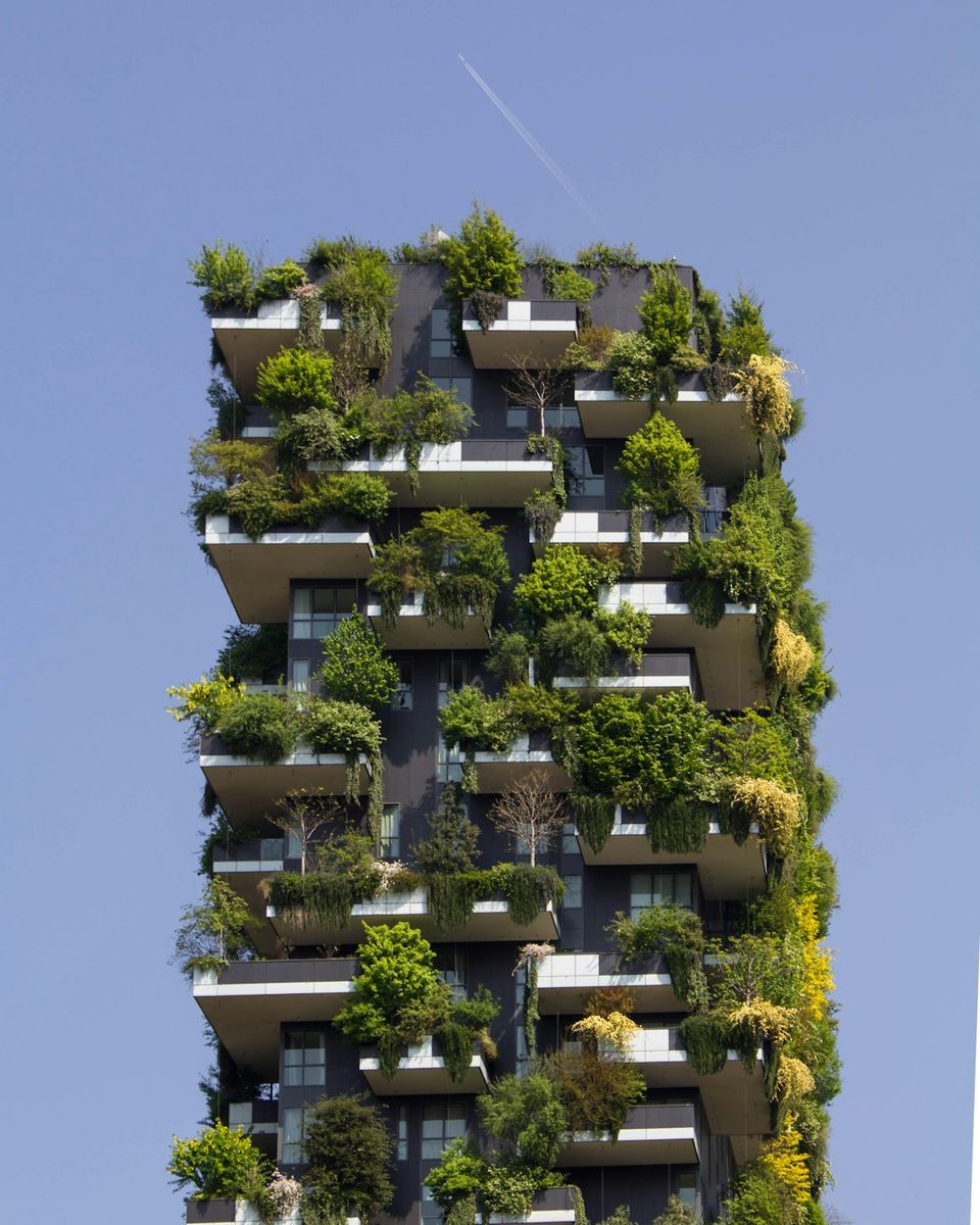 High-rise tower enveloped by lush balcony gardens and tree-filled terraces, showcasing a modern vertical forest design that appeals to eco-conscious clients.