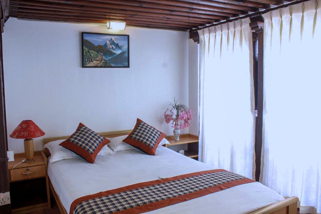 Indrayani double bed with cushions beneath exposed timber beams