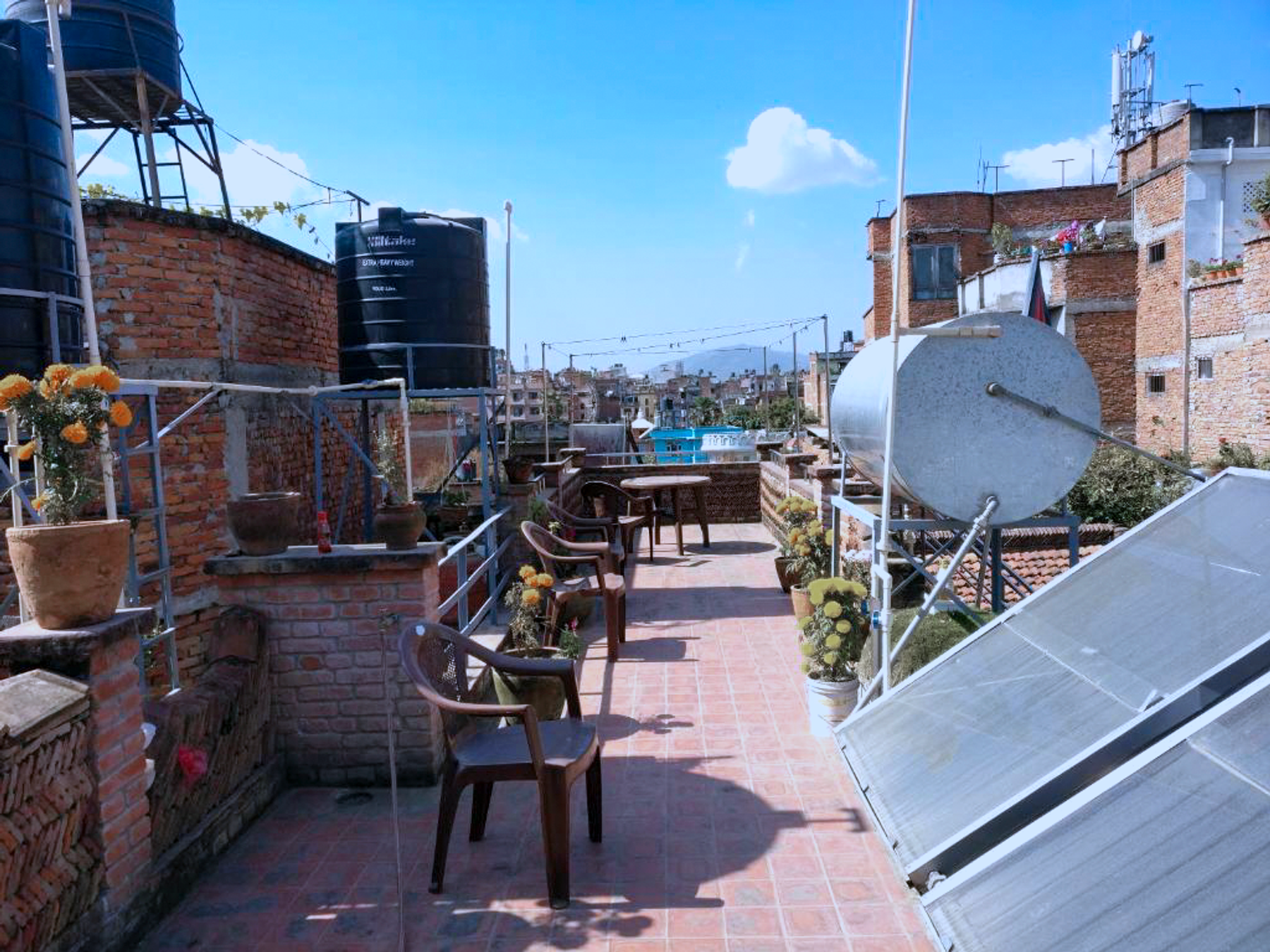 Tables and chairs on the rooftop shared by the two apartments