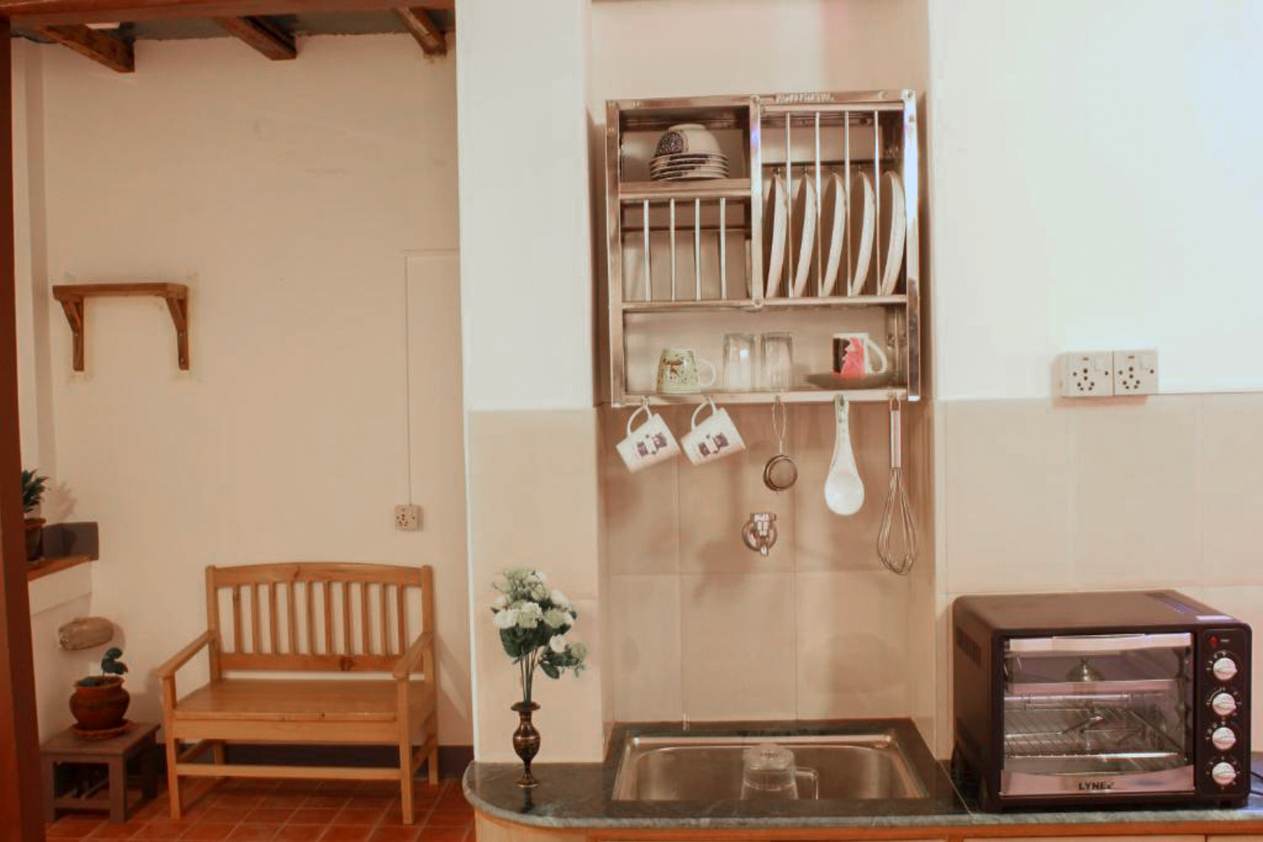 Mahalaxmi sitting area with shelves of cups and kitchenware