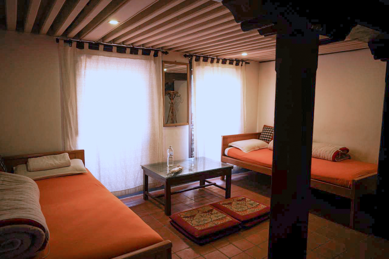 A guest room with original beams and a carved lattice window