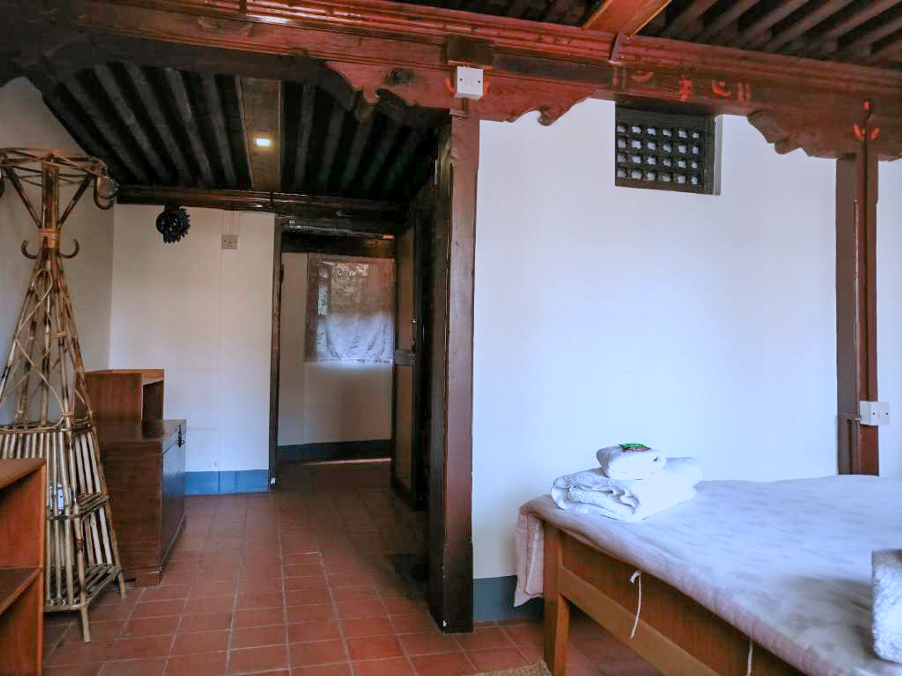 Indrayani entrance with a clothes stand beside the double bed