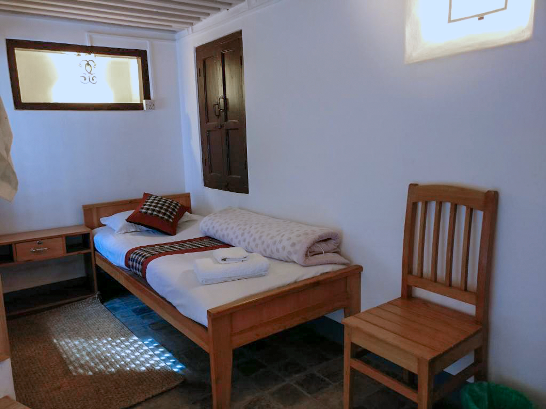Kumari single bed with a bedside table and wooden chair
