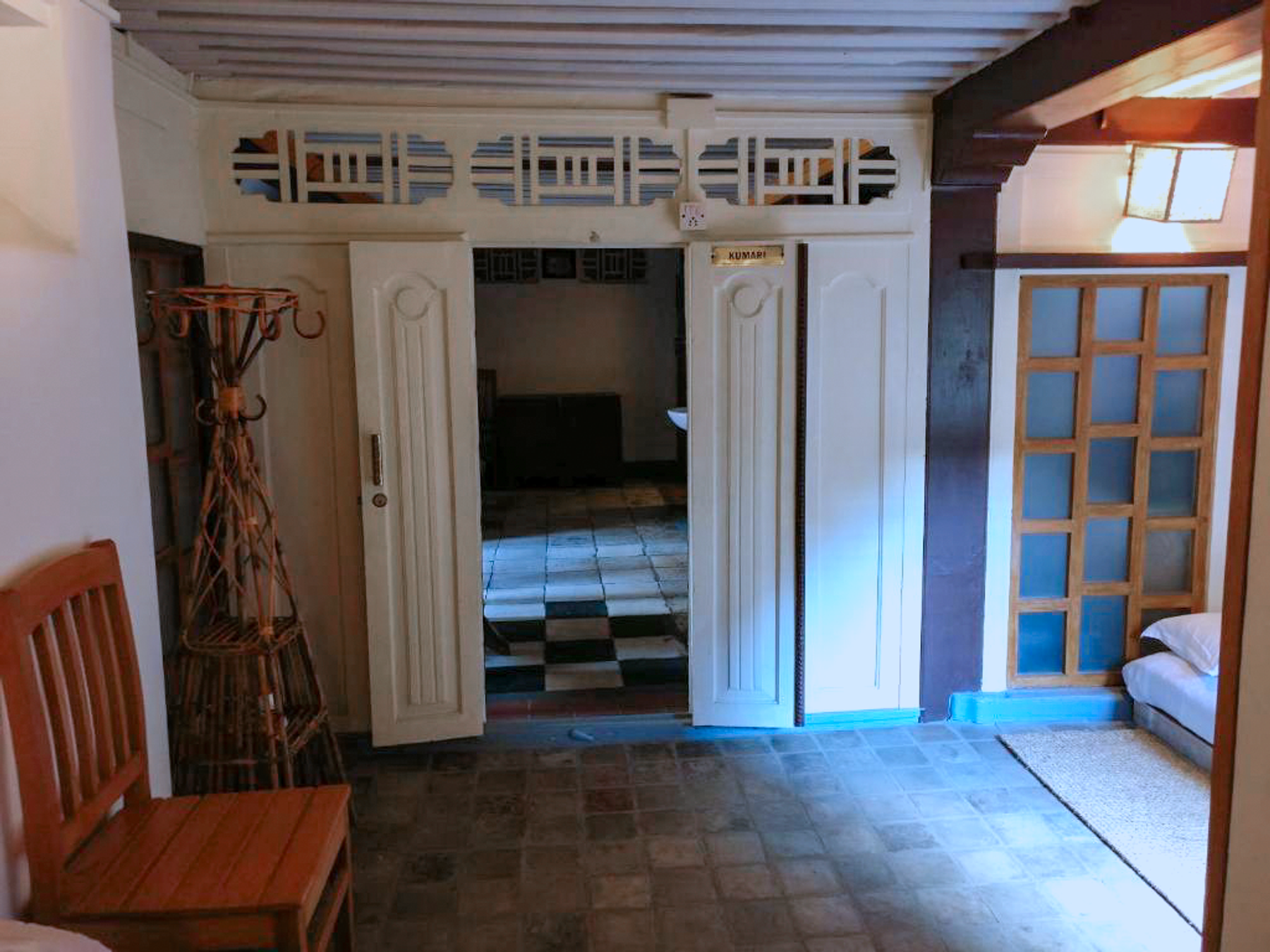 Kumari entrance with a chair and floor mattress beneath exposed beams