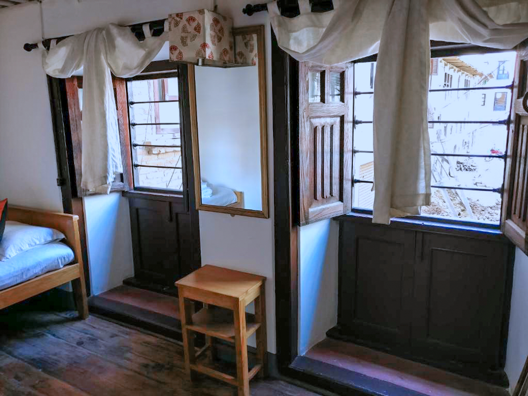Barahi wooden windows with a mirror, chair and small table