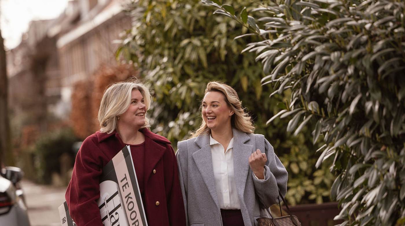 Twee mensen bekijken het woningaanbod in de etalage van Hart & Huis