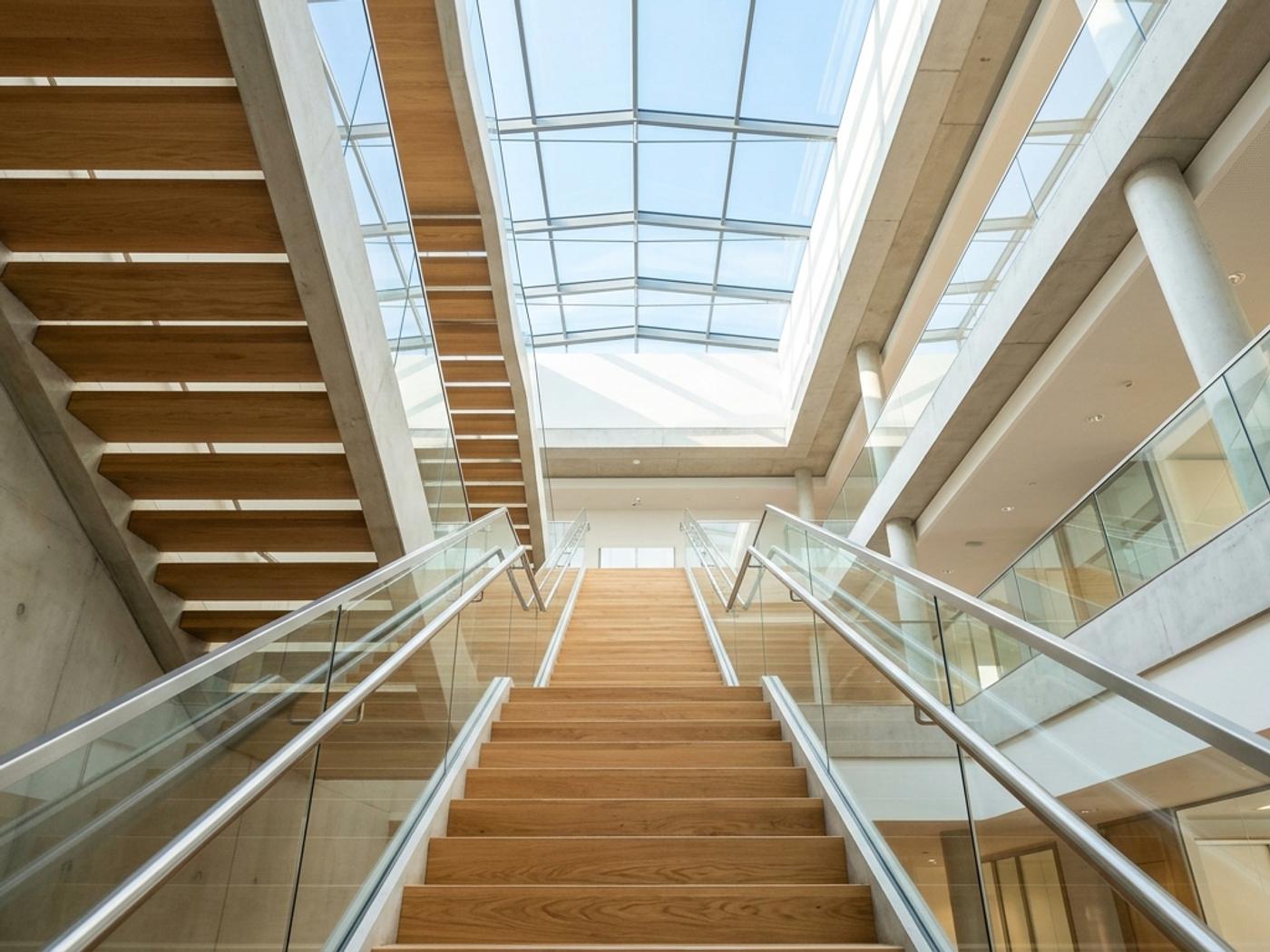 Modern office staircase with natural light from above, representing progressive stages of organizational growth