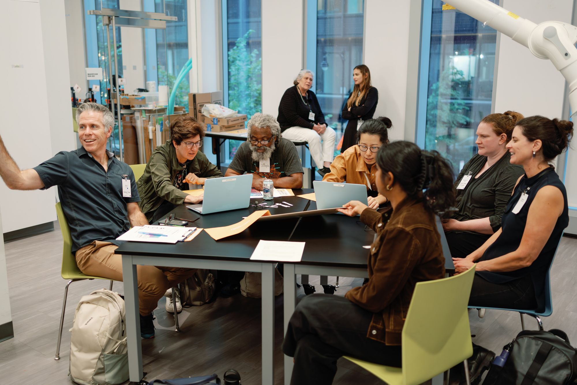 A group of participants laugh and chat while they work through their project.