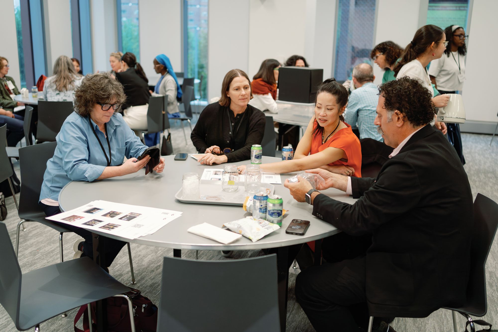 A group of engaged participants lean over a paper as they discuss.