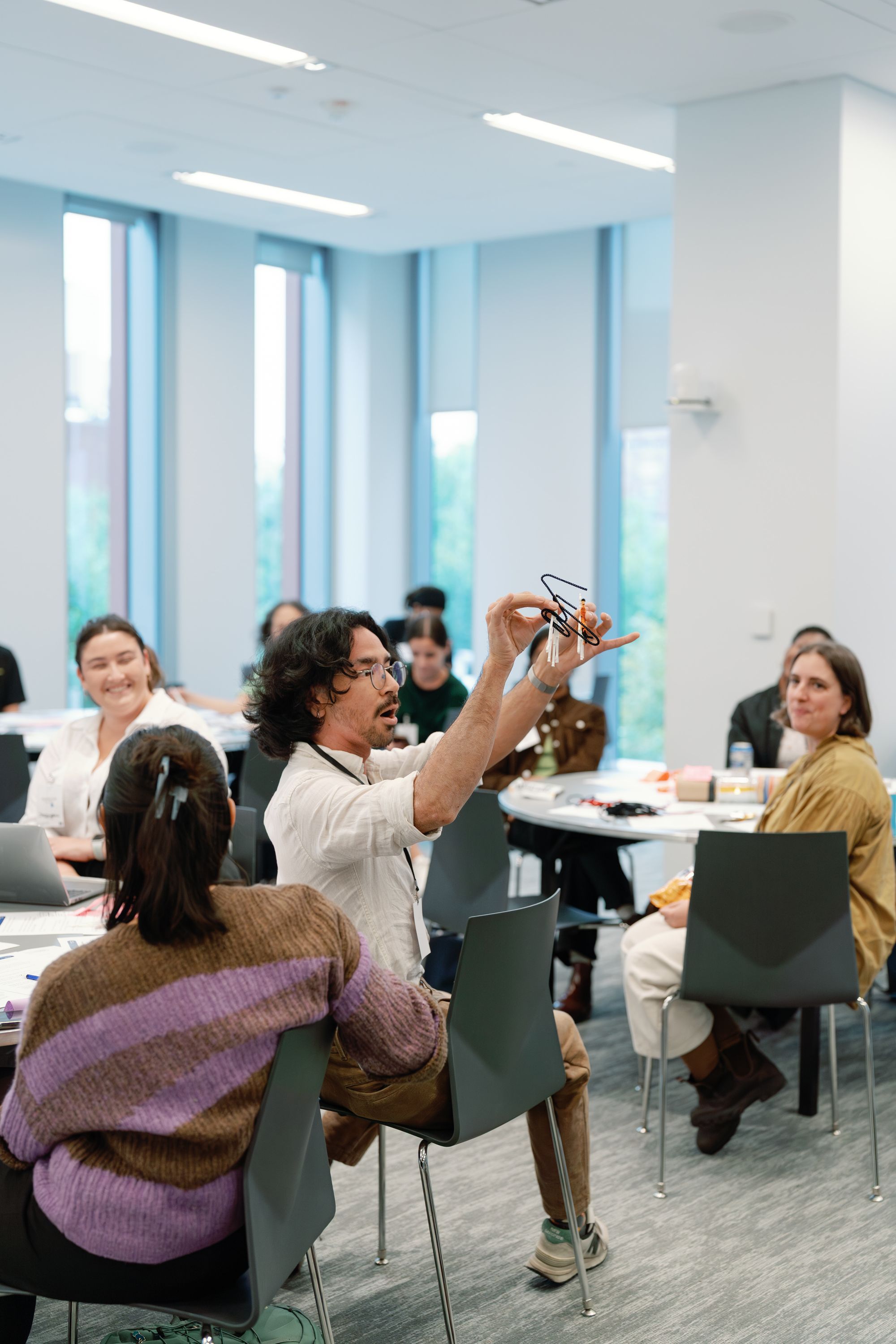 An educator presents a creation designed from small, bendable objects.