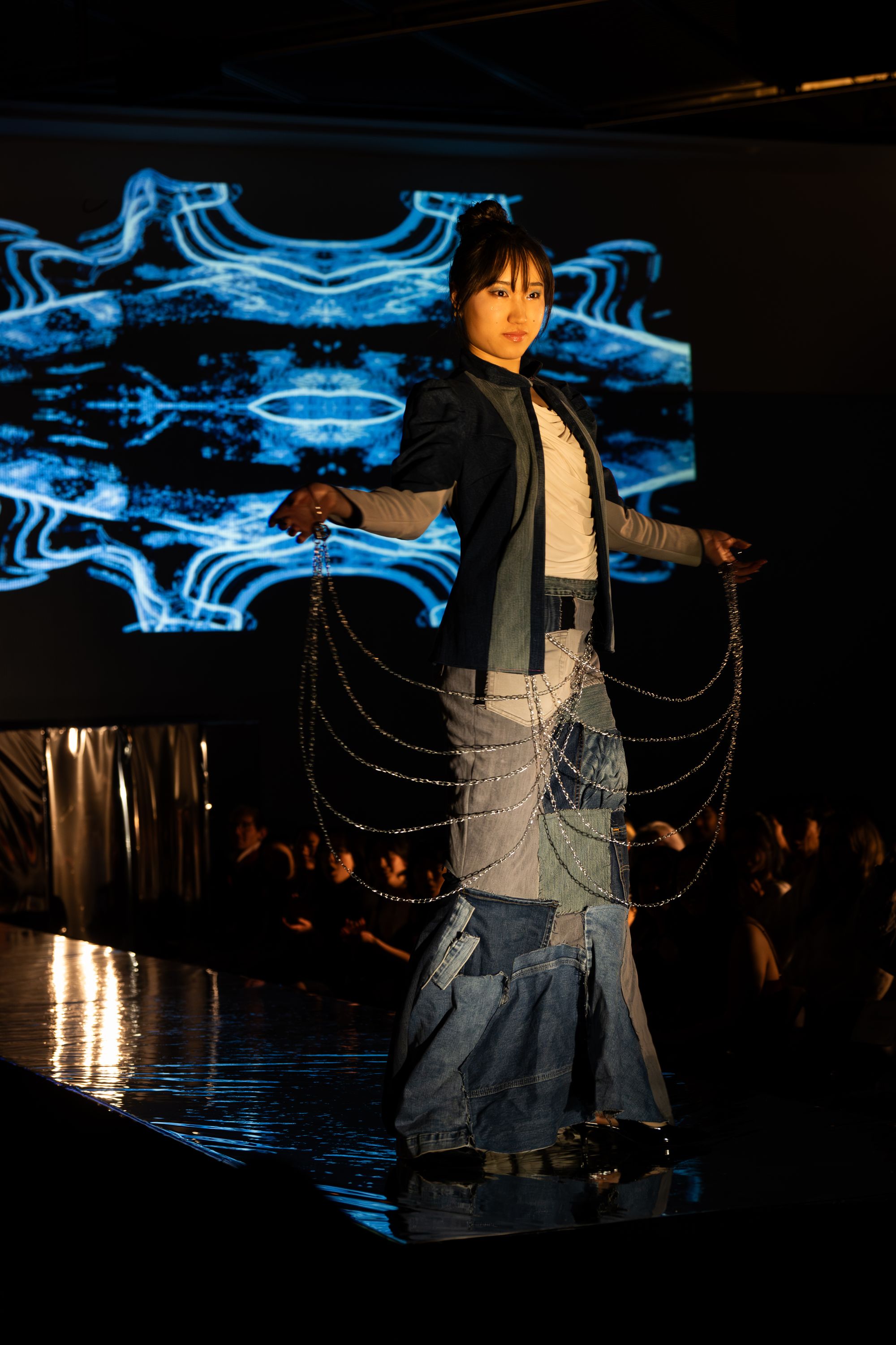 Designed by Lawrence Liu '26 and modeled by Phoebe Xu, "When It Rains, It Pours," is a mermaid dress made of secondhand denim contrasted with a structured blazer. "The mermaid dress was embellished with a crisscross weave of hardware chain, adding glimmer as the model walked," describes Lawrence. Photo: Jules DailPhoto: Jules Dail