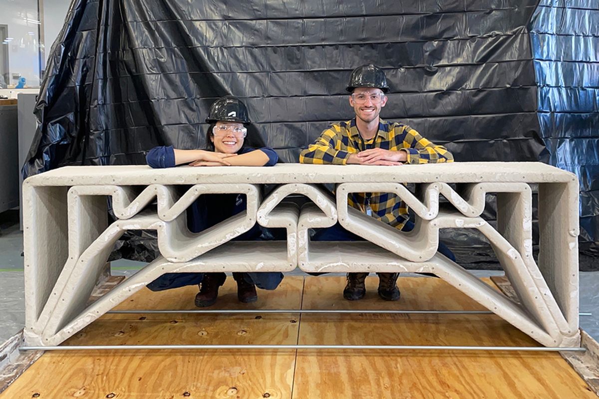 MIT Department of Civil and Environmental Engineering postdoc Hajin Kim-Tackowiak (left) and graduate student Zane Schemmer pose with the 3D-printed concrete bridge they designed and load-tested.