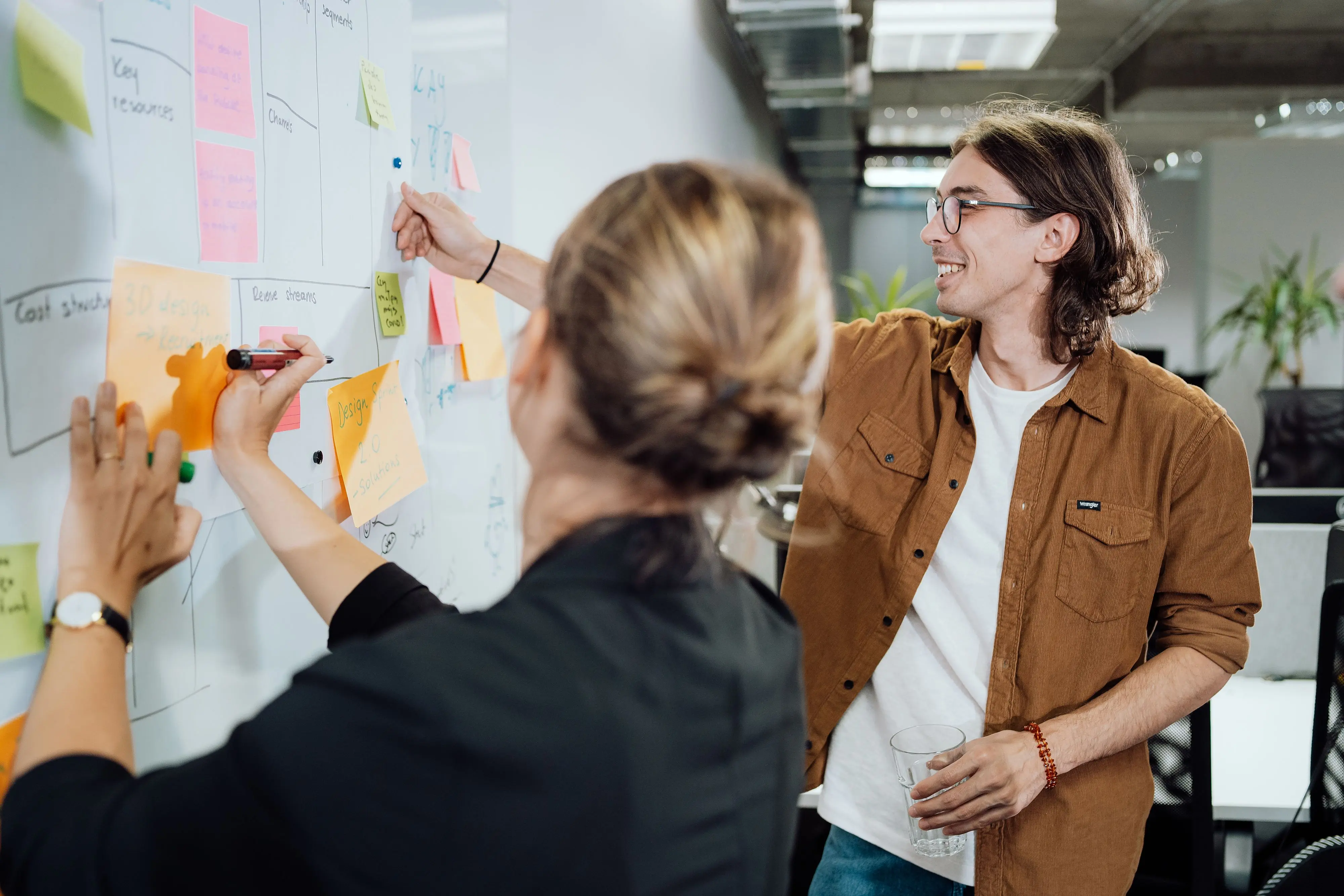 People project planning on a whiteboard with post it notes. 