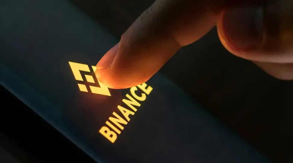 A finger pressing the entrance screen of the Binance App