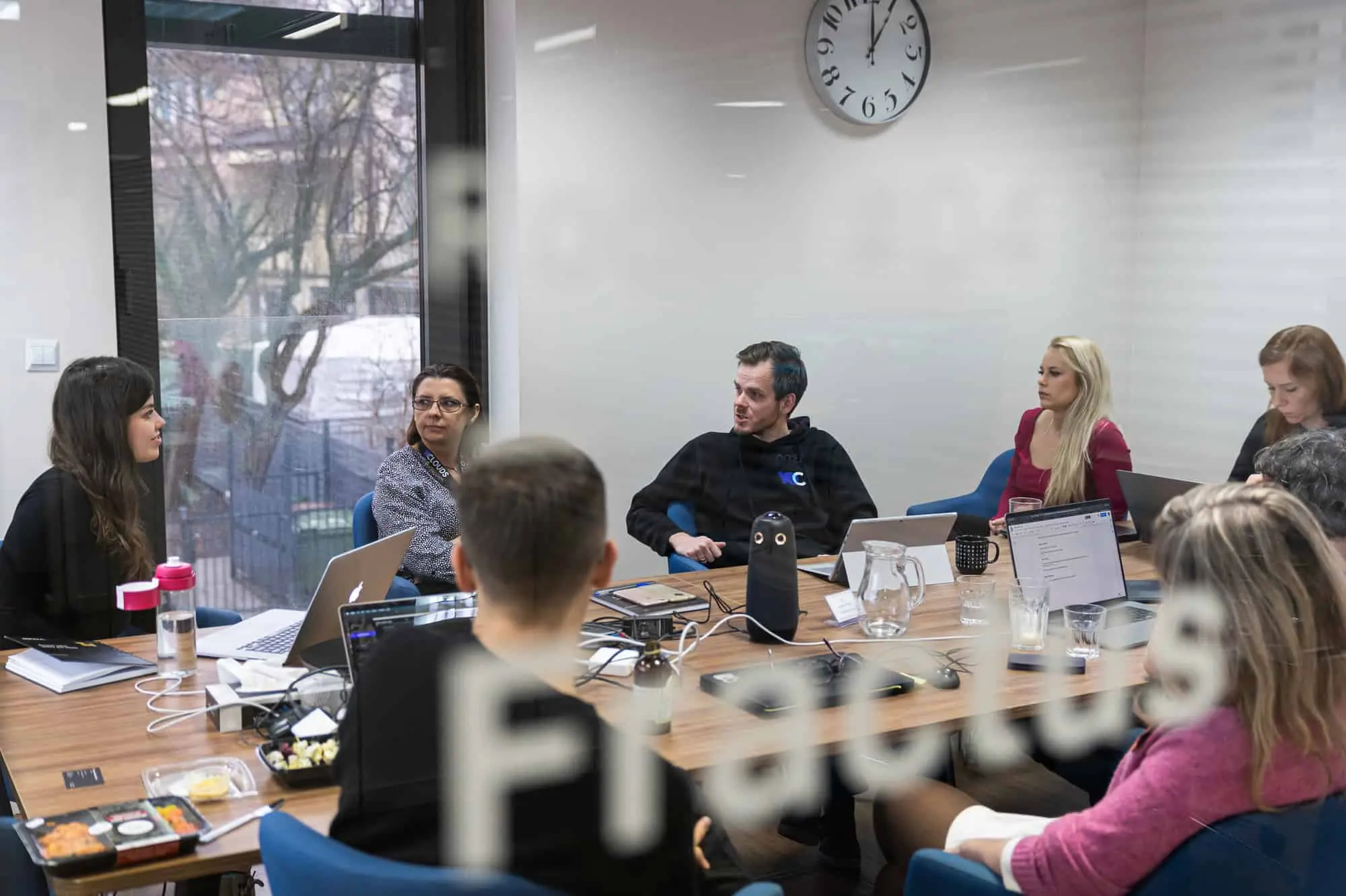 A meeting of people gathered around a desk discussing Agile principles