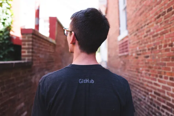 The back of a man who is wearing a GitHub Tshirt