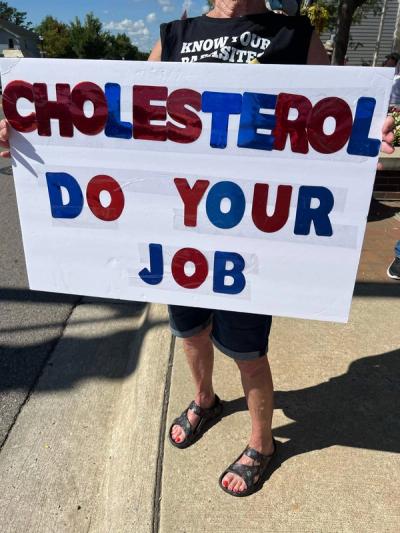 A cheeky sign that reads "Cholesterol Do Your Job."