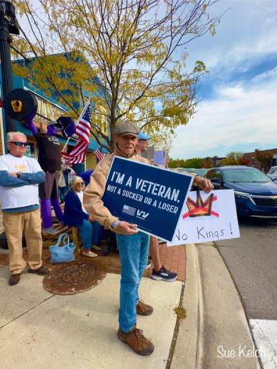 A veteran at the Saline Indivisible No Kings protest with a sign that reads, "I'M A VETERAN. NOT A SUCKER OR A LOSER."