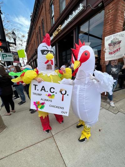 Peaceful protesters in Saline (MI) wore inflatable chicken, dinosaur, flamingo, baby, fallguy, ostrich, and, of course, frog costumes!