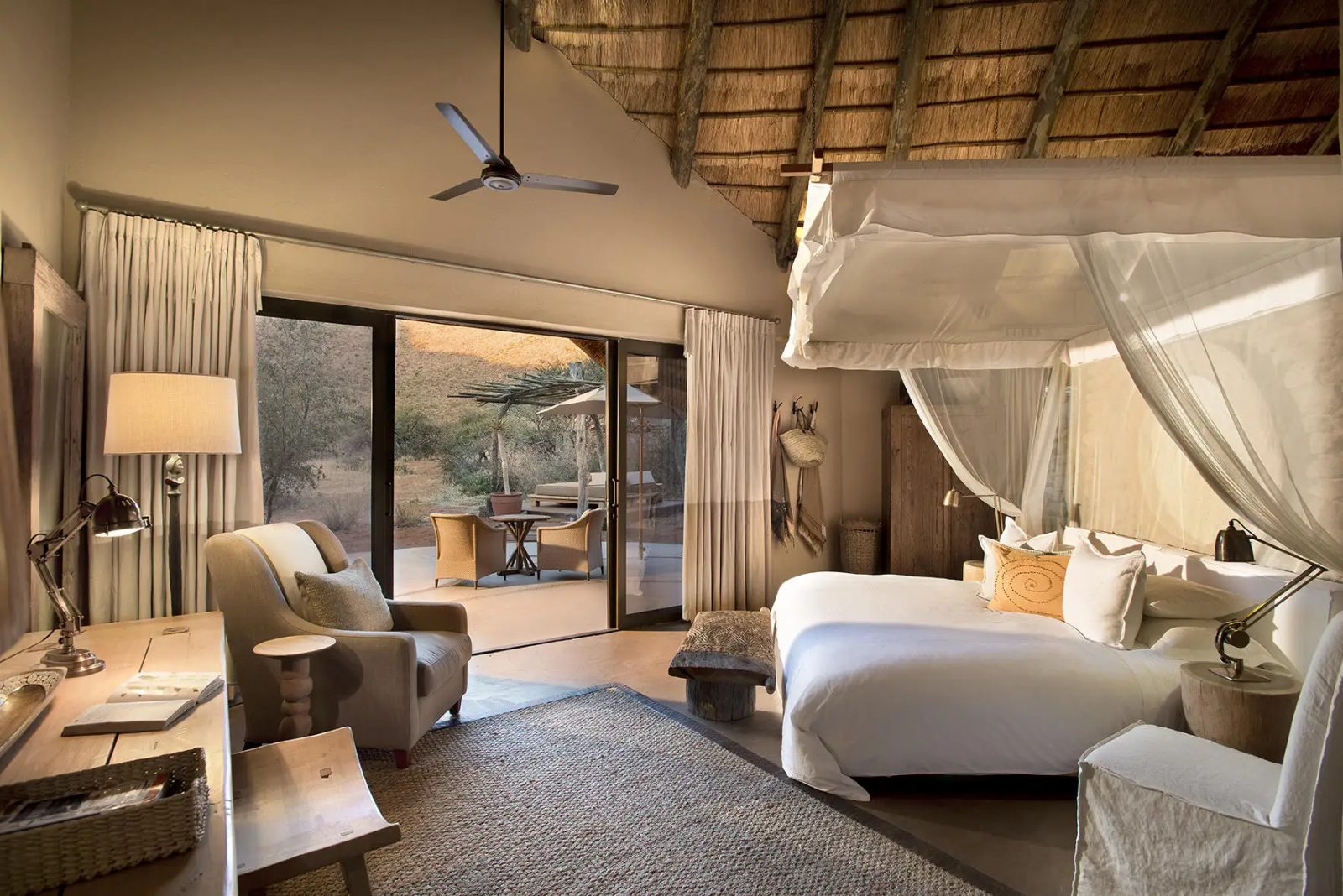 Luxury rooms featuring a canopy bed and sliding glass doors that open to a vast desert landscape