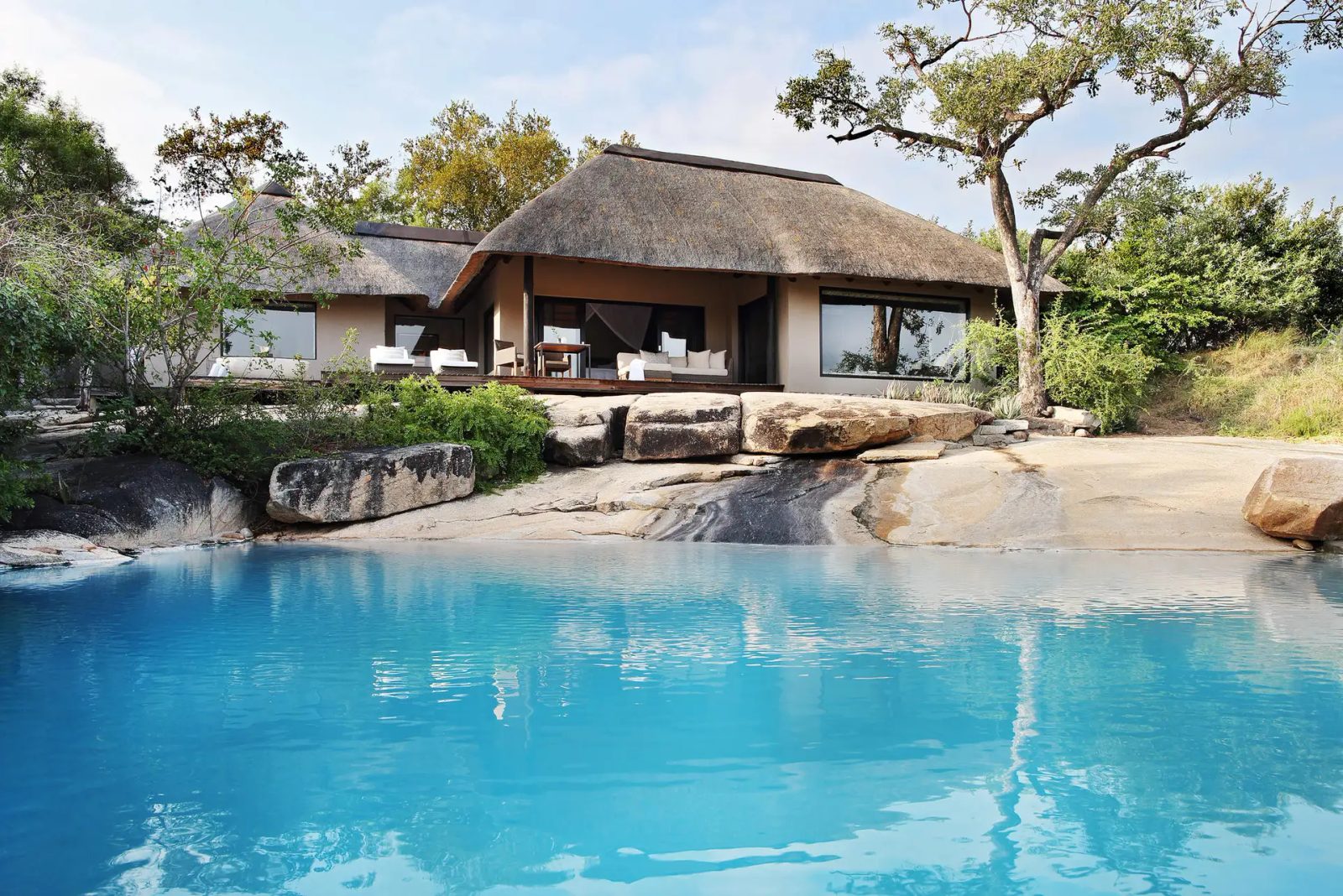 Thatched Londolozi Granite Suite above a turquoise plunge pool set into granite boulders
