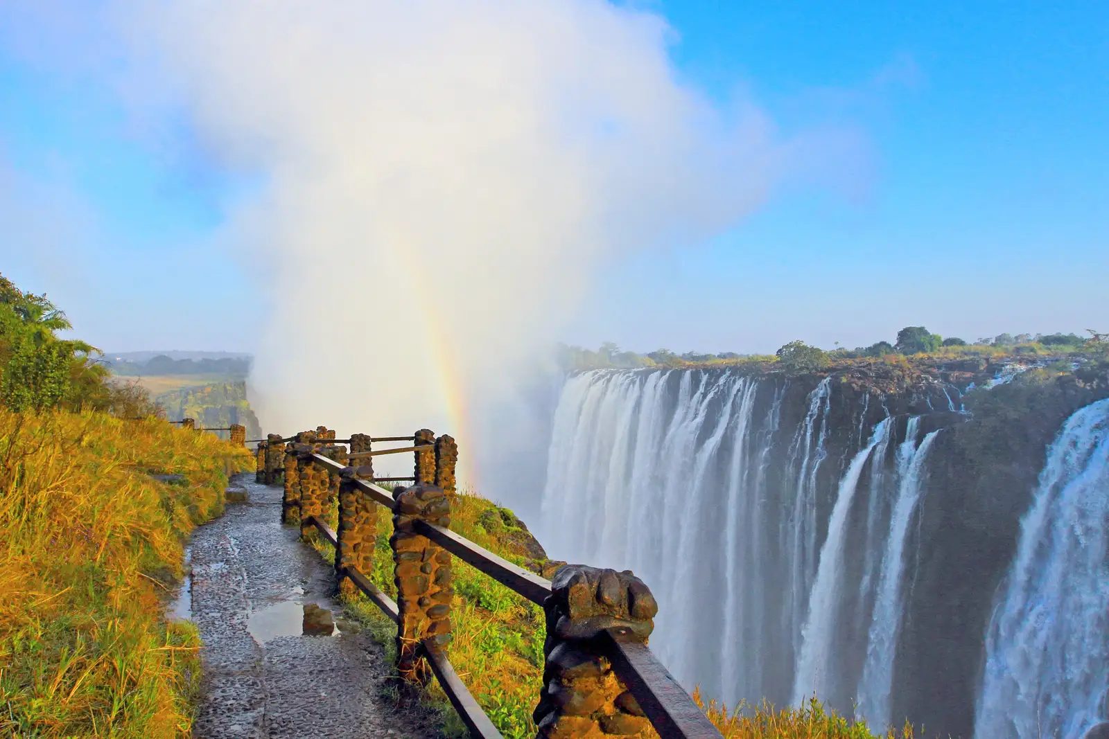 A stone walkway overlooking mist and powerful cascades