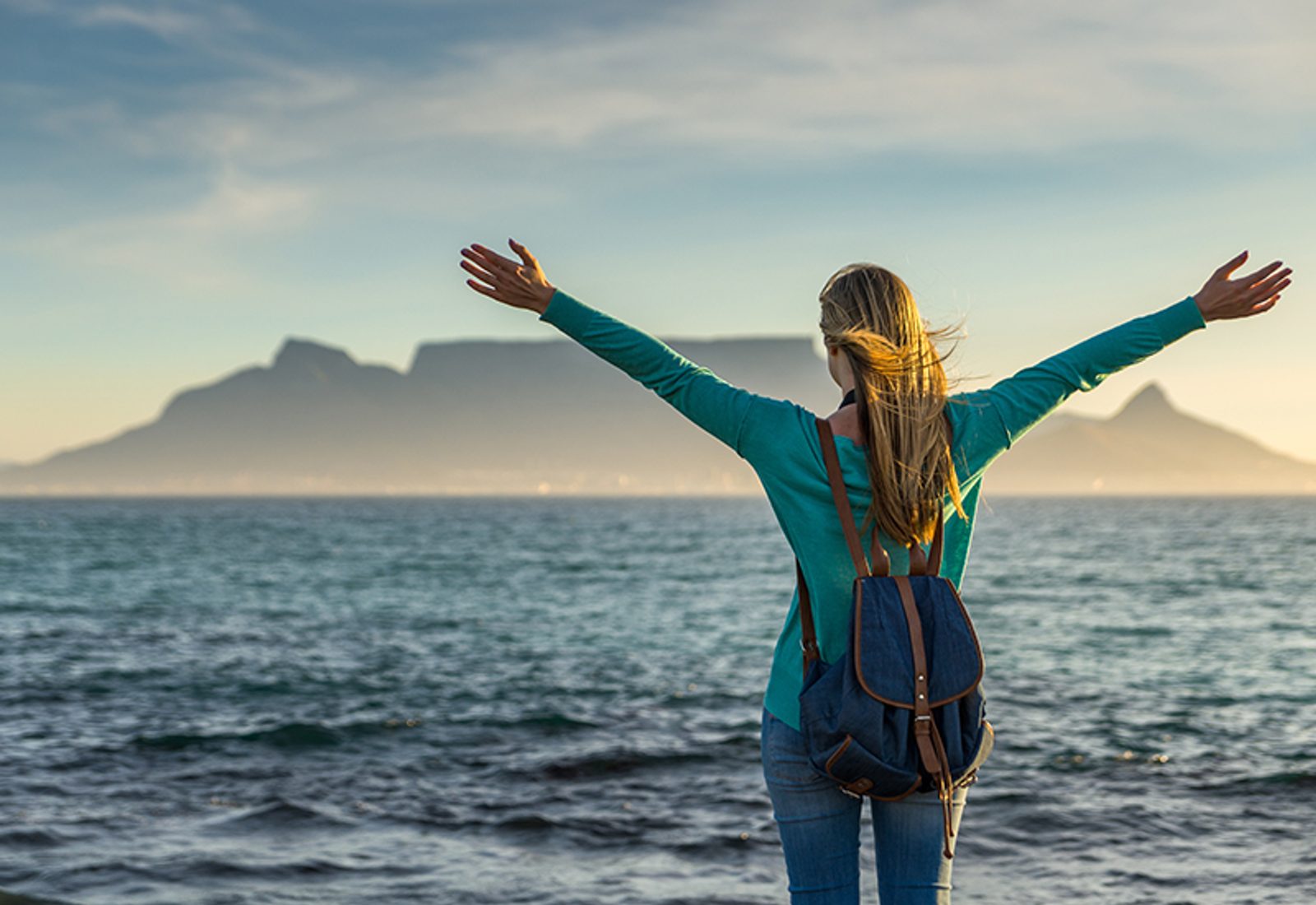 woman-standing-on-the-beach-in-front-of-table-mountain