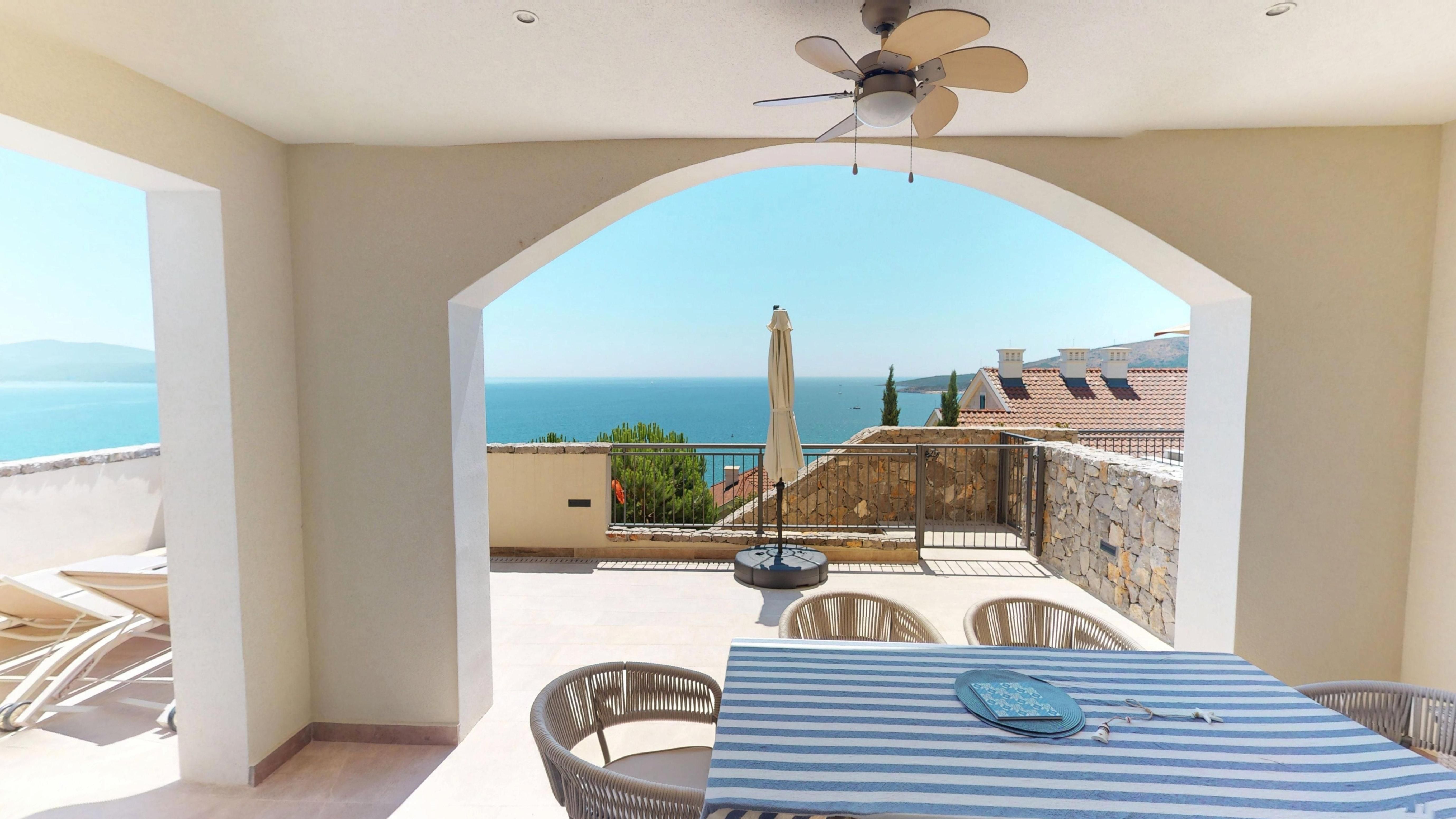 Covered dining terrace framing an open Adriatic sea view at Apartment I802 in Marina Village, Luštica Bay