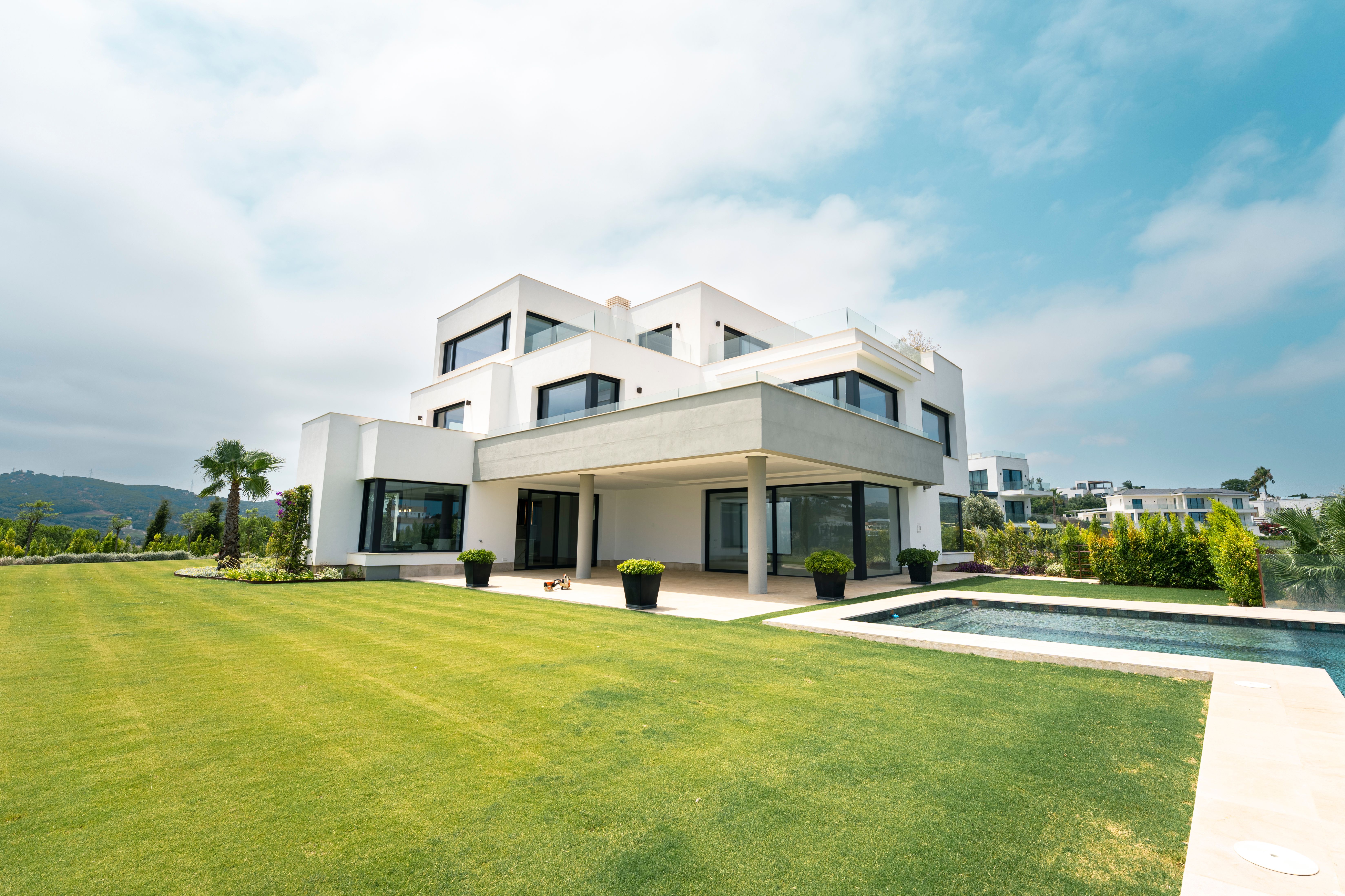 Contemporary villa with lawn, covered terrace and infinity pool