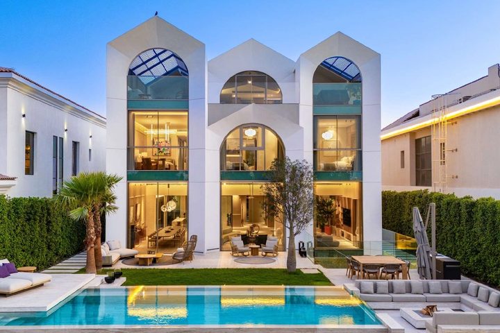 Wildflower villa and swimming pool at dusk in Jumeirah Golf Estates, Dubai