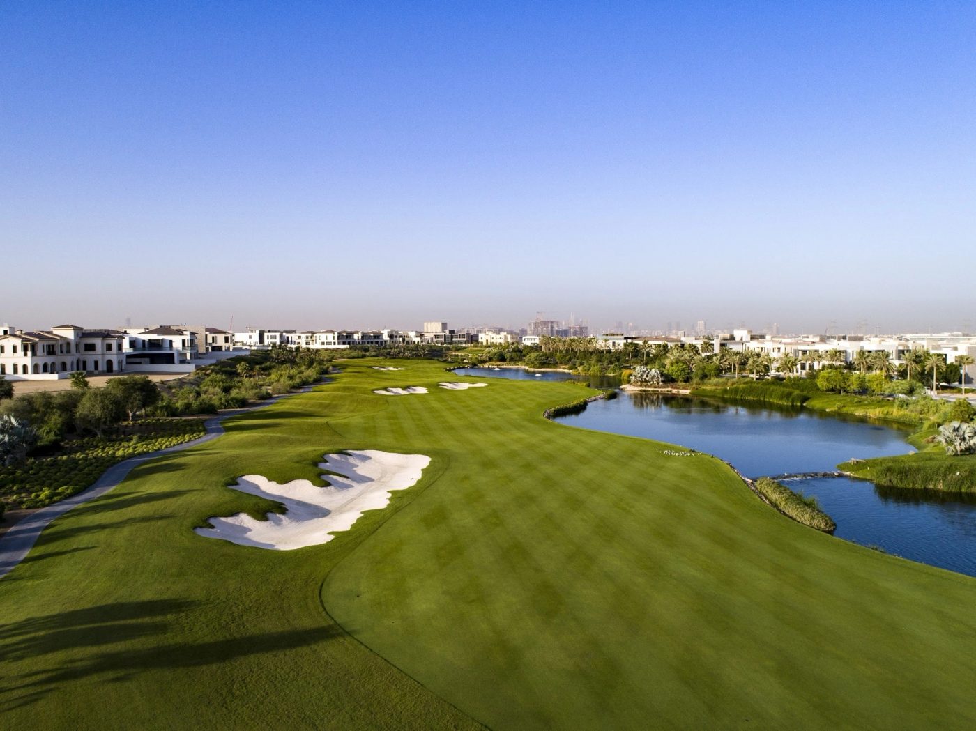 Fairways, bunkers, lakes and nearby villas at Dubai Hills Golf Club.